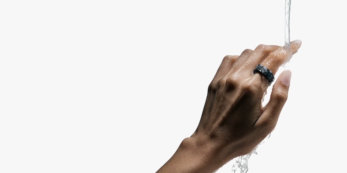 Akan suyun altında parmağında Galaxy Ring olan el